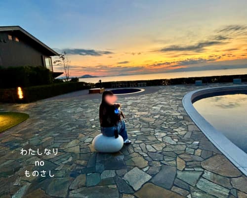 蒼の湖邸ビワフロント彦根のプールサイドで、夕日に染まる琵琶湖を背景にもももを抱いている様子